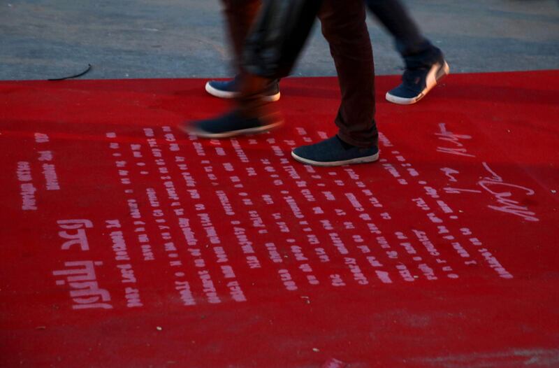 Youths step on a text of Balfour Declaration which is printed onto a 100-meter red carpet during opening ceremony of the 3rd Annual Red Carpet Festival for Human Rights Films at the fishermen port in Gaza City, Friday, May 12, 2017. The Red Carpet Festival is held in Gaza for the third year which coincides with one hundred years for The Balfour Declaration, marks the right of return, the release of hunger strikers imprisoned in Israeli jails, the return of national unity and the end of the internal division. (AP Photo/Adel Hana)