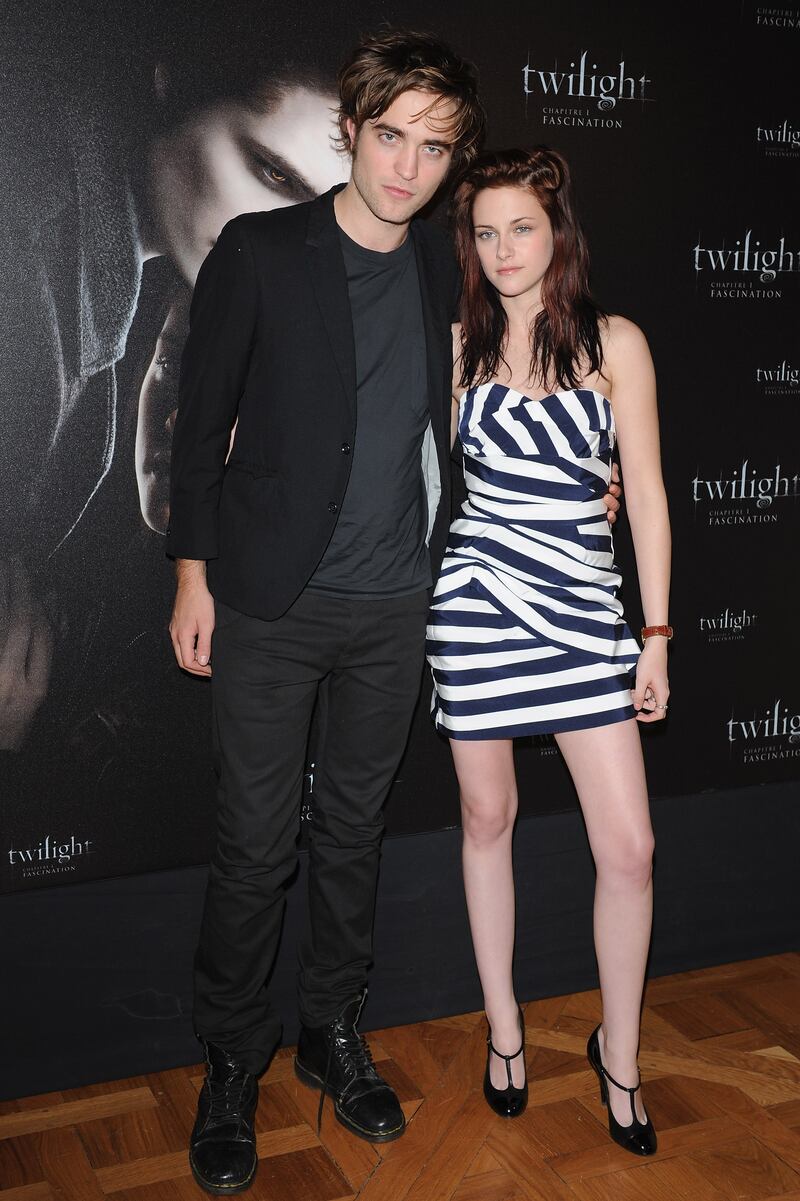 Wearing black trousers and a black jacket, Robert Pattinson poses with Kristen Stewart during a 'Twilight' photocall in Paris on December 8, 2008. Getty Images