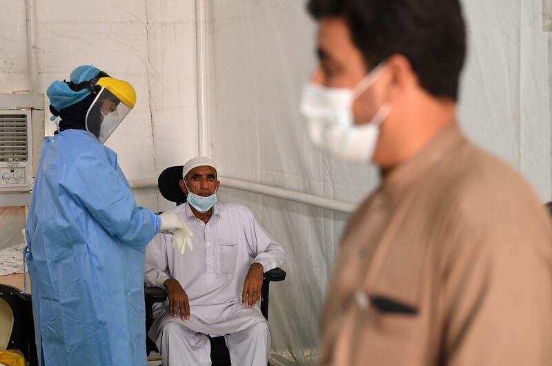 A health worker tests a man for Covid-19 at a clinic in Al Quoz, Dubai. Karim Sahib / AFP