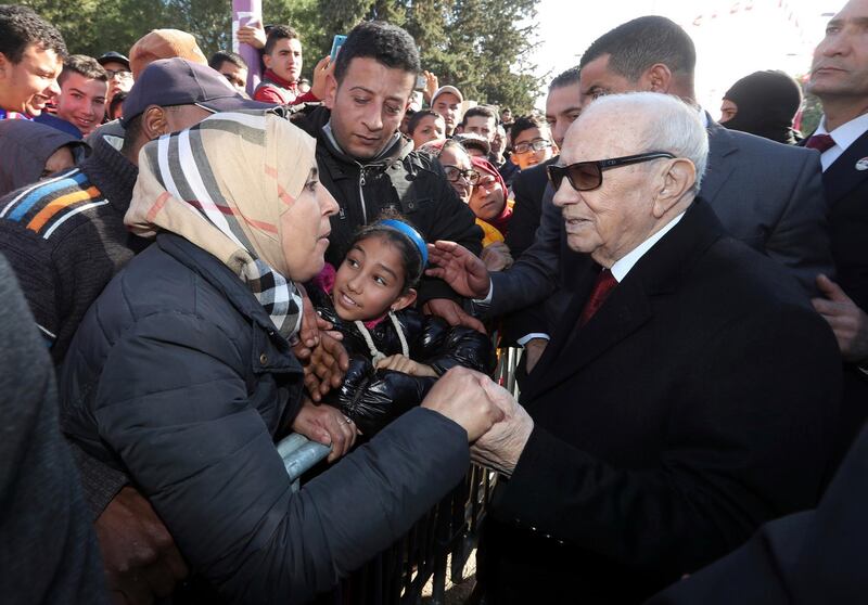 Tunisian President Beji Caid Essebsi shake hands with bystanders as he arrives for a event in Tunis, Tunisia, Sunday, Jan. 14, 2018. Tunisian authorities announced plans to boost aid to the needy in a bid to placate protesters whose demonstrations over price hikes degenerated into days of unrest across the North African nation, which is marking seven years on Sunday since its long-time autocratic ruler was driven into exile.(Slim Abid/Tunisian Presidency via AP)