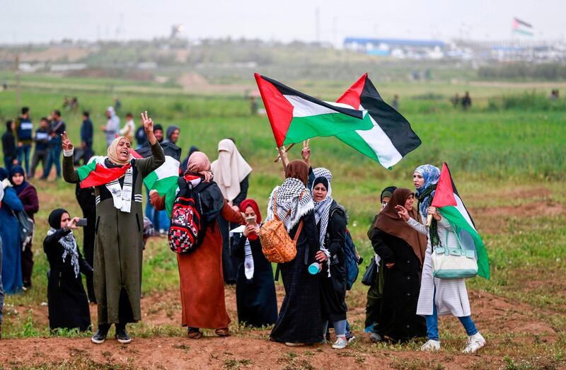 Women protesters flash the victory sign and wave Palestinian flags during a demonstration. AFP