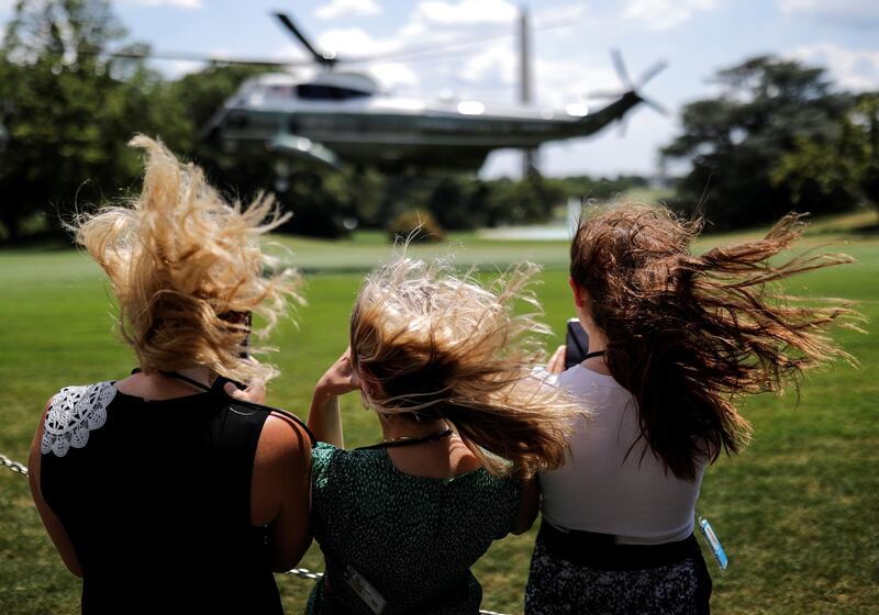 Visitors withstand a strong gust of wind created by Marine One as they watch the helicopter ascend with US President Donald Trump aboard departing for travel to Atlanta, Georgia, from the South Lawn at the White House in Washington. Reuters