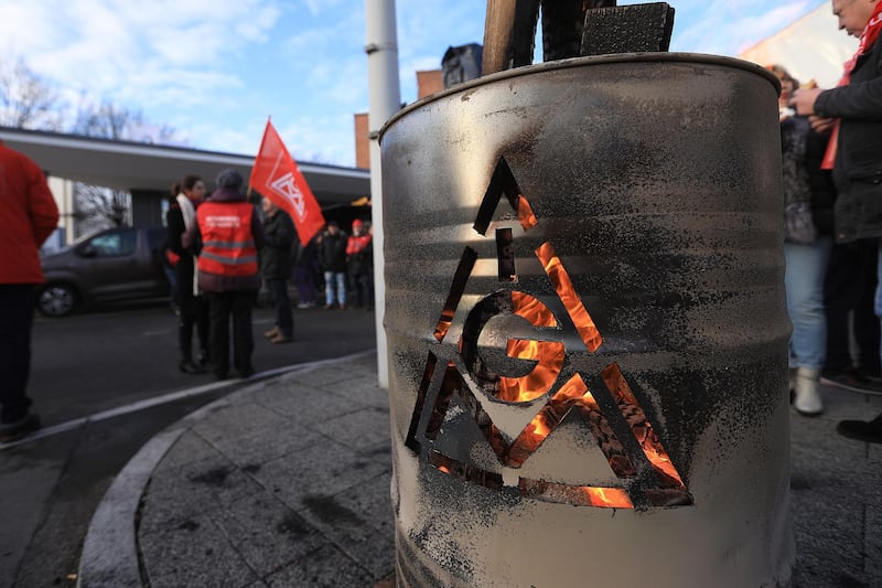 The IG Metall logo sits on a burning brazier barrel during a 24 hour strike called by the labor union outside the BMW Motorrad motorcycle factory, operated by Bayerische Motoren Werke AG, in Berlin, Germany, on Friday, Feb. 2, 2018. Workers at industrial giants from Siemens AG to Daimler AG escalated a labor dispute with a series of day-long strikes across Germany that employers said will severely disrupt production. Photographer: Krisztian Bocsi/Bloomberg