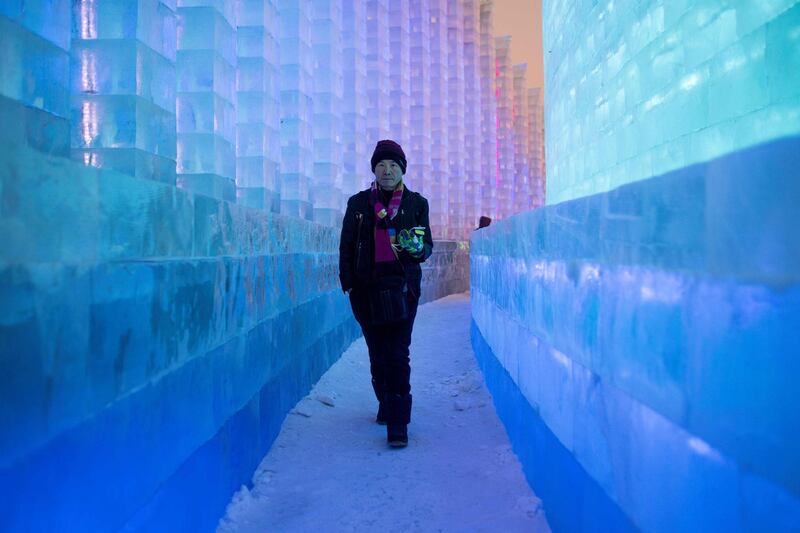 A visitor walks through ice sculptures. AFP