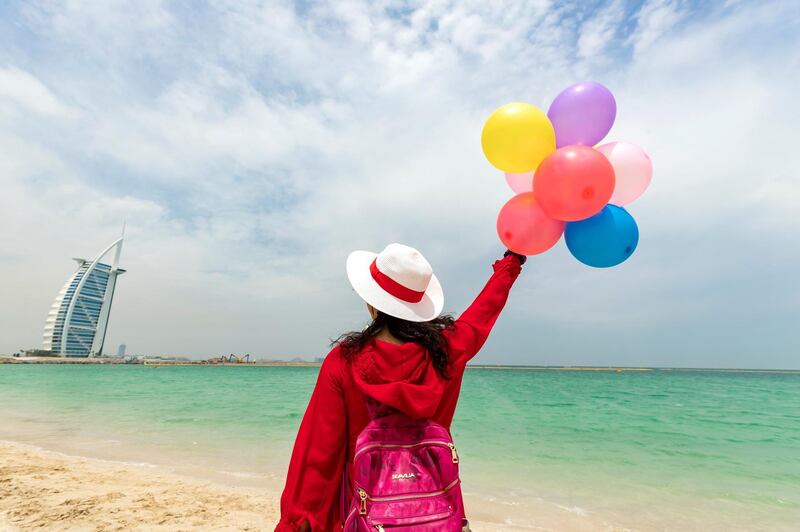 Dubai, United Arab Emirates - May 19, 2019: Chinese tourists on the beach on a cloudy and windy day in Dubai. Sunday the 19th of May 2019. Jumeirah, Dubai. Chris Whiteoak / The National