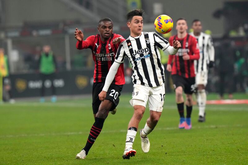 Paulo Dybala is challenged by Pierre Kalulu during a Serie A match between AC Milan and Juventus at the San Siro stadium in Milan, Italy, Sunday, January  23, 2022.  AP