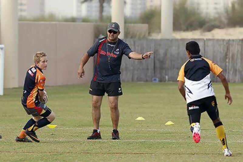 Sharks UAE Rugby Academy coach Steve Botha works with youth players on the training pitch Tuesday. Mike Young / The National