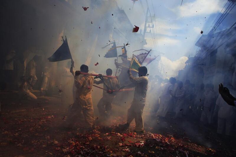 Devotees of Chao Pho Kuan U shrine carry a statue through exploding firecrackers during a street procession during the annual vegetarian festival in Phang Nga, Thailand. Athit Perawongmetha / Reuters