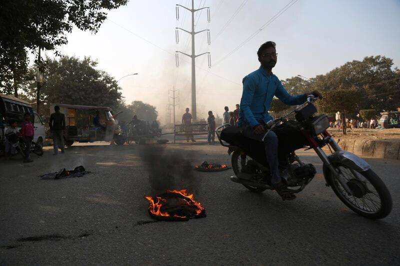 Protesters burn tires while blocking a main road during a protest after a controversial court decision in Karachi, Pakistan.  AP Photo