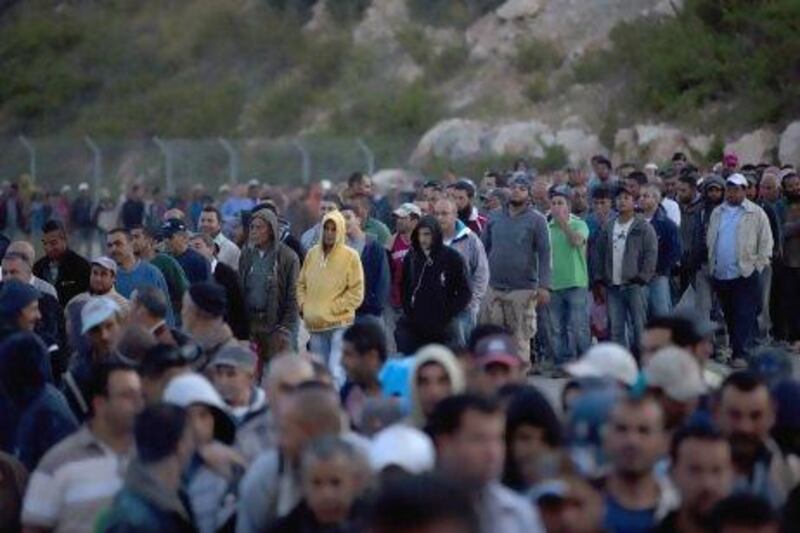 Palestinian labourers wait to cross into Israel at a checkpoint near the West Bank village of Nilin. Palestinian leaders say a US offer of billions in aid won't solve the conflict with Israel.