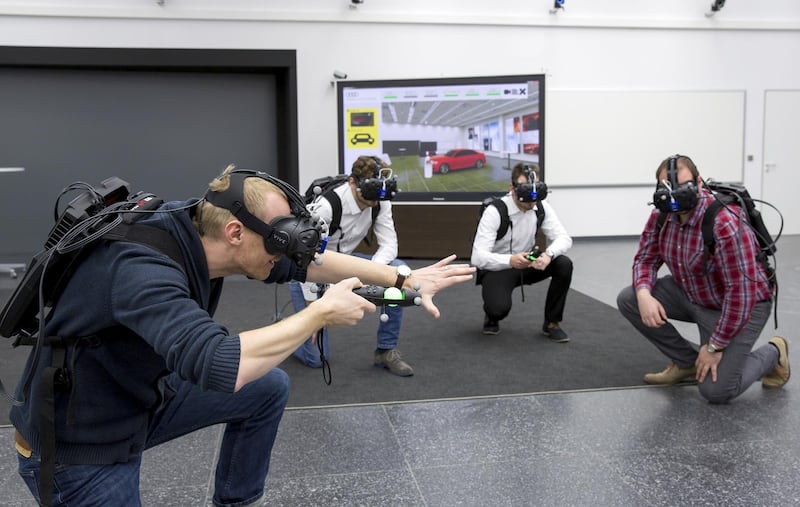 Martin Rademacher (left) and his colleagues from Audi’s planning are testing the Virtual Reality Holodeck to assess the design of a new automobile model.