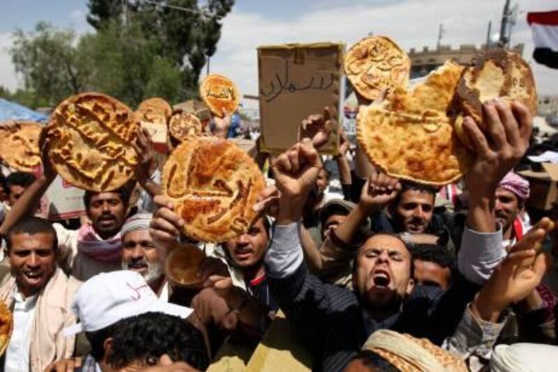 Yemenis hold loaves of bread reading in arabic "Leave" during a protest against the regime of President Ali Abdullah Saleh in Sanaa on March 6, 2011 after the embattled leader refused to resign by the end of the year, a day after the president, who has ruled the impoverished, deeply tribal nation since 1978, dismissed opposition calls for his resignation by the end of the year and vowed to stay on until 2013.    AFP PHOTO / AHMAD GHARABLI
 *** Local Caption ***  456733-01-08.jpg