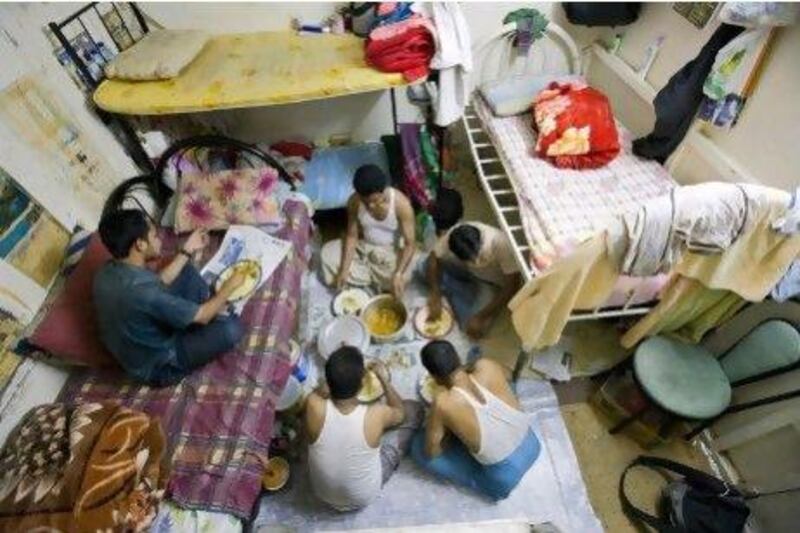 Five Bangladeshi men have supper in a room at  " Bachelor's Building"Five Bangladeshis have supper in a room at the ‘Bachelor’s Building’, a block of flats where only male expatriates workers can live.