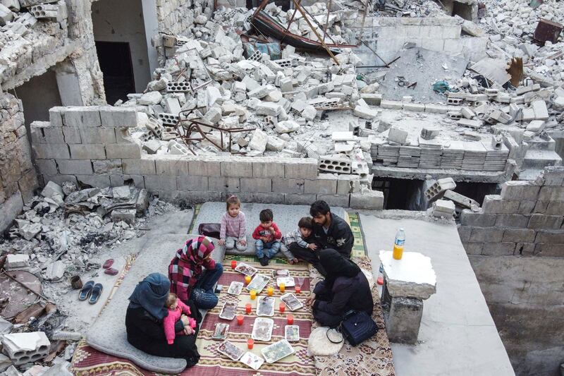 Members of the displaced Syrian family of Tariq Abu Ziad, from the town of Ariha, Idlib, reaking their fast together for the sunset iftar meal. AFP