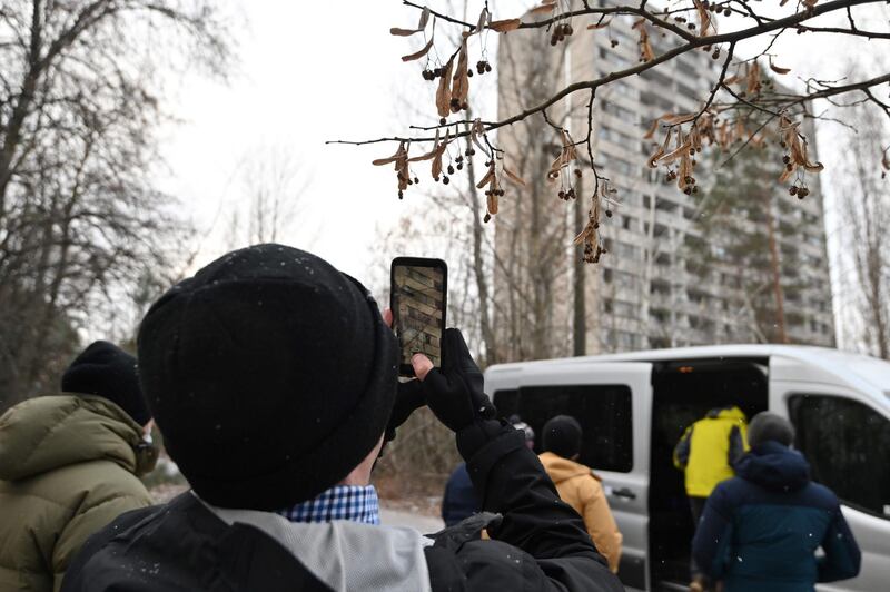 A visitor takes a smartphone picture of abandoned buildings in the ghost town of Pripyat, not far from Chernobyl nuclear power plant.  AFP