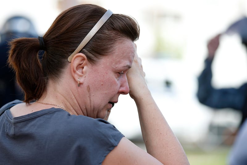 A woman reacts as she stands outside a school following a shooting in Kazan. AP Photo