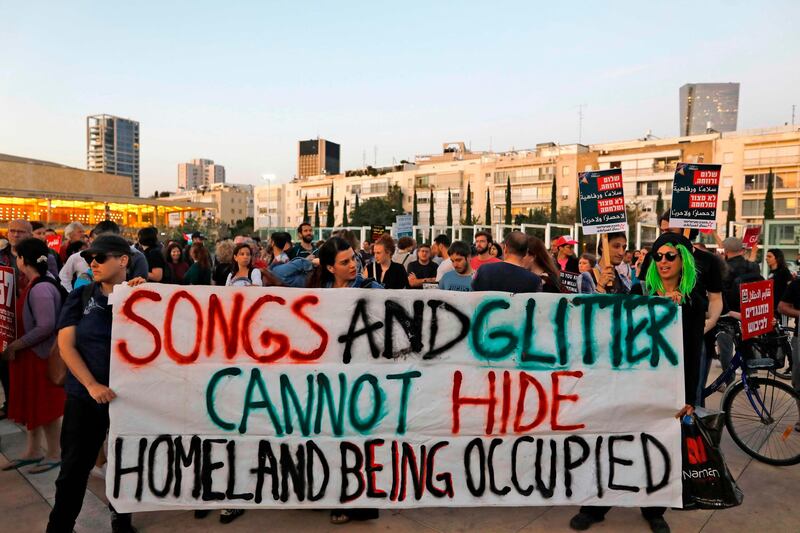 Left-wing Israelis hold slogans during a protest against Eurovision in Tel Aviv. AFP