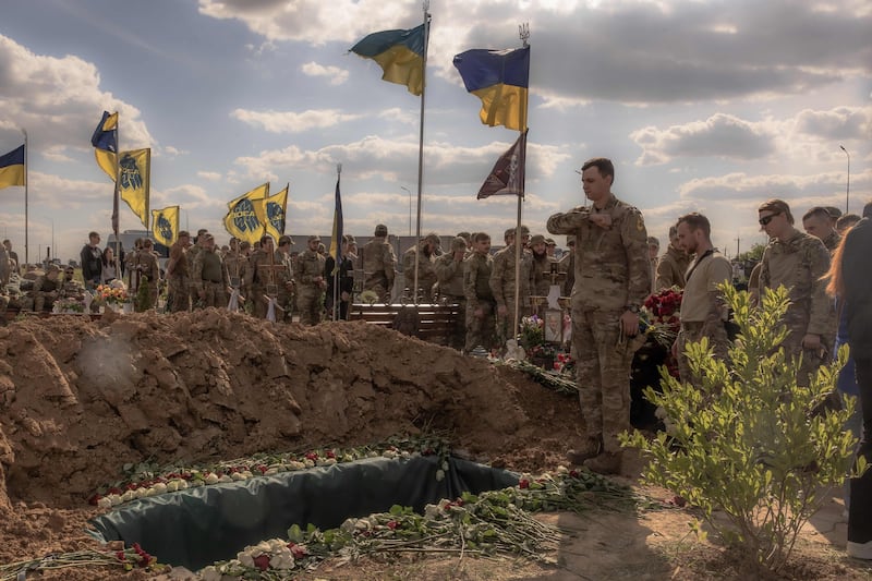 Ukrainian fighters pay their respects at the grave of a soldier in Vinnytsia last month. AFP