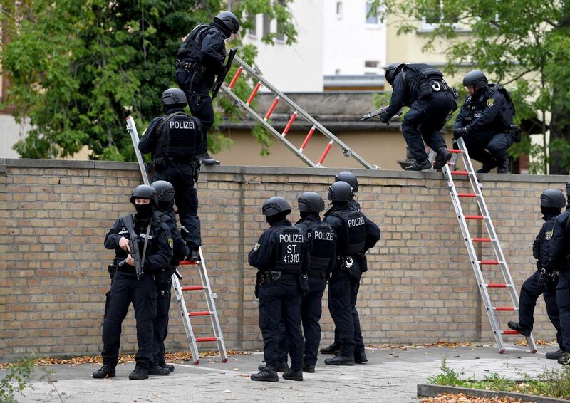 epa07907572 Police officers climb over the cemetery wall of a Synagogue after a shooting in Halle, Germany, 09 October 2019. According to the police two people were killed in shootings in front of a Synagogue and a Kebab shop in the Paulus district of Halle in the East German federal state of Saxony-Anhalt. Police stated a suspect is already in arrest. Media report the mayor of Halle speaks of an amok situation.  EPA/FILIP SINGER