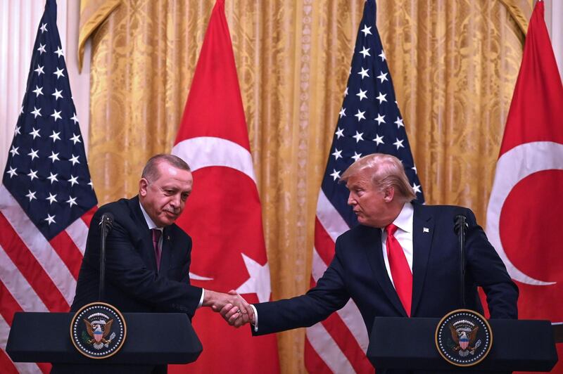 TOPSHOT - US President Donald Trump and Turkey's President Recep Tayyip Erdogan (L) take part in a joint press conference in the East Room of the White House in Washington, DC on November 13, 2019. President Donald Trump greeted his Turkish counterpart Recep Tayyip Erdogan at the White House for a high-stakes meeting Wednesday that underlined his claim to be ignoring the impeachment drama unfolding simultaneously in Congress. / AFP / JIM WATSON
