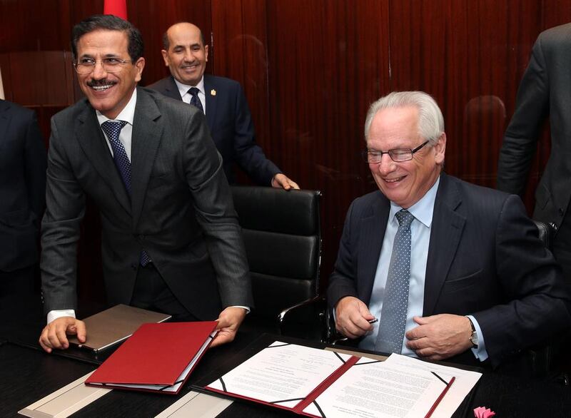 Sultan Al Mansouri, the UAE Minister of Economy, left, with the UK trade and investment minister Francis Maude while UAE ambassador to the Abdulrahman Ghanem Almutaiwee, back, looks on during a signing ceremony. Stephen Lock for the National