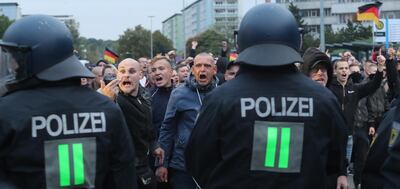 epaselect epa06990846 Right-wing protesters shout behind a row of police men in Chemnitz, Germany, 01 September 2018. Organizations of civil society and right-wing groups  called for several  demonstrations on the weekend after two refugees from Syria and Iraq were arrested on suspicion of stabbing a 35-year-old man in what police described as a 'scuffle between members of different nationalities' at a city festival in the East German city Chemnitz.  EPA/MARTIN DIVISEK