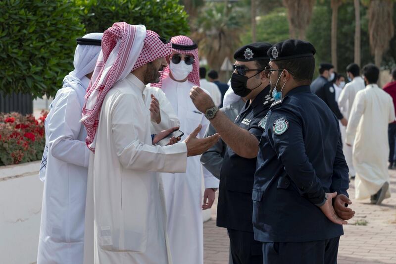 Demonstrators speak with police officers as they gather in front of Kuwait National Assembly building. Reuters