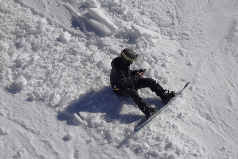 A snowboarder takes a rest.