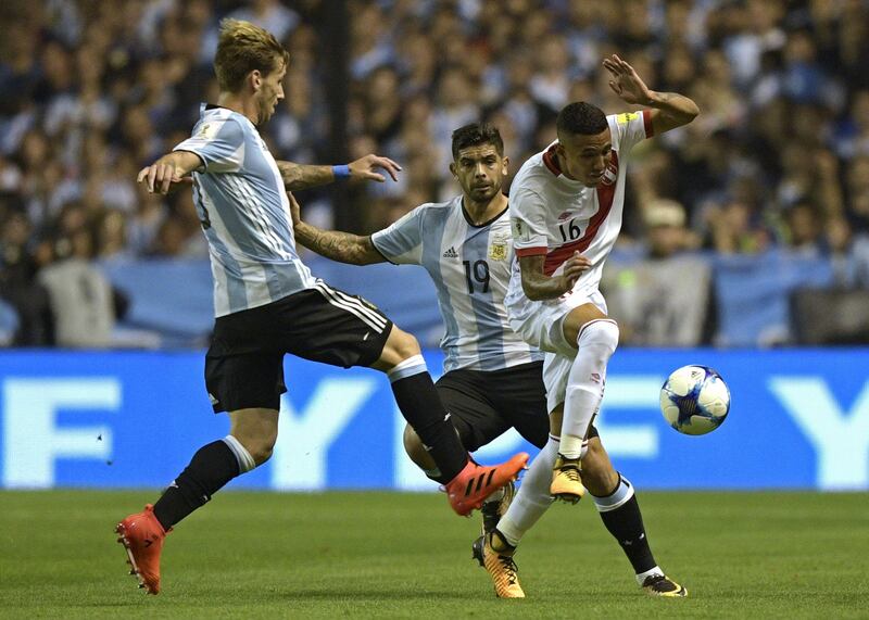 Peru's Sergio Pena (R) is marked by Argentina's Lucas Biglia (L) and Ever Banega during their 2018 World Cup qualifier football match in Buenos Aires on October 5, 2017. / AFP PHOTO / Juan MABROMATA