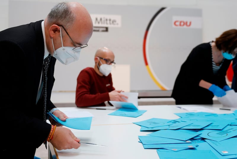Masked delegates count votes that arrived by mail for the election of the new head of Germany's conservative CDU party, in Berlin. AFP