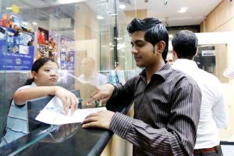 A man checks the rates at a Deira exchange before remitting money back to Pakistan.