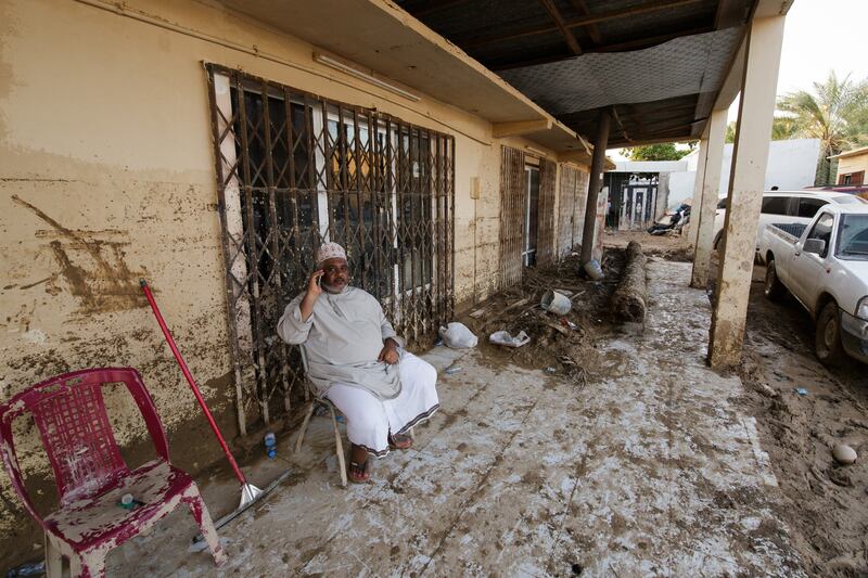Abdullah Al Balushi sits outside his house waiting for clean-up support to arrive.