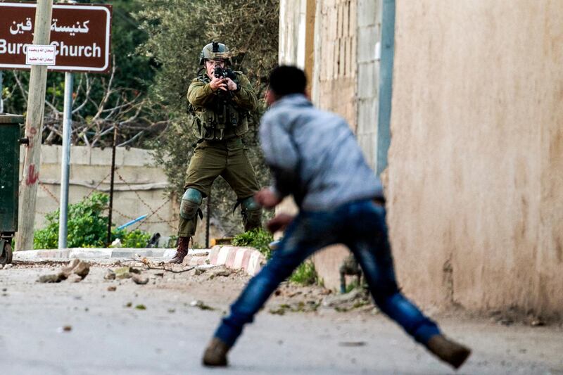 A Palestinian protester confronts an Israeli soldier during an army search operation in the Palestinian village of Burqin in the occupied West Bank. Jaafar Ashtiyeh / AFP Photo