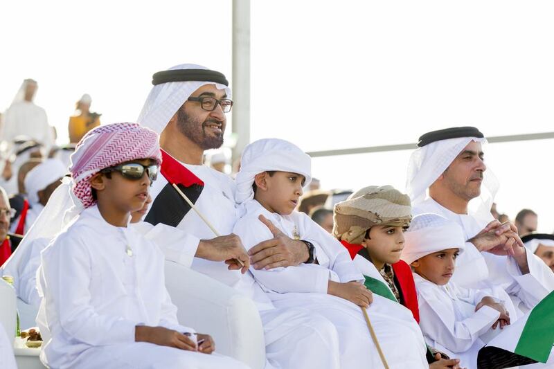 Sheikh Mohammed bin Zayed, sitting with Sheikh Saif bin Zayed, Deputy Prime Minister and Minister of Interior, right, as they watch a performance at the Sheikh Zayed Heritage Festival in Al Wathba on the UAE’s 42nd National Day in December. Ryan Carter / Crown Prince Court — Abu Dhabi