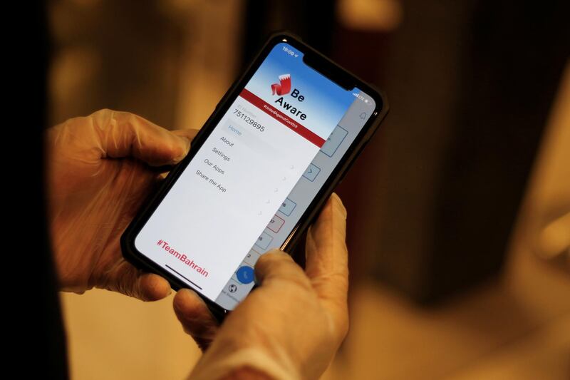 A man wearing protective gloves checks the app "Be Aware", launched by Bahrain's health authorities to contain the coronavirus disease by spreading awareness and sharing updates on the situation. Reuters