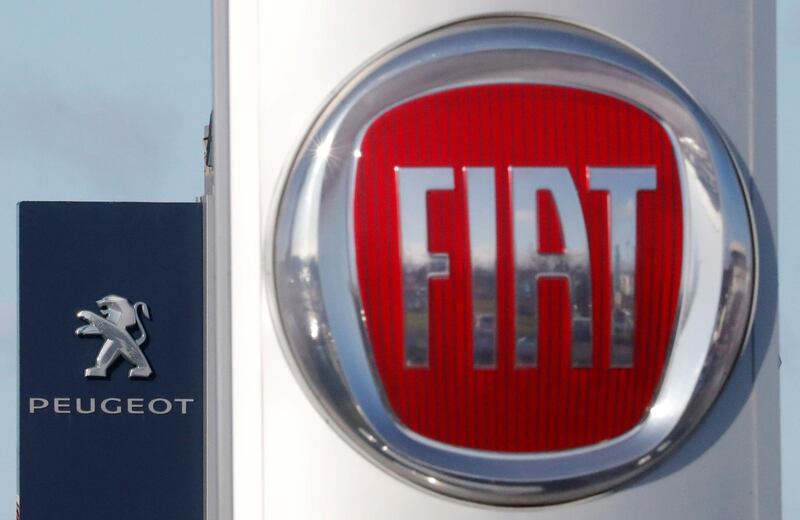 FILE PHOTO: The logos of car manufacturers Fiat and Peugeot are seen in front of dealerships of the companies in Saint-Nazaire, France, November 8, 2019. REUTERS/Stephane Mahe/File Photo