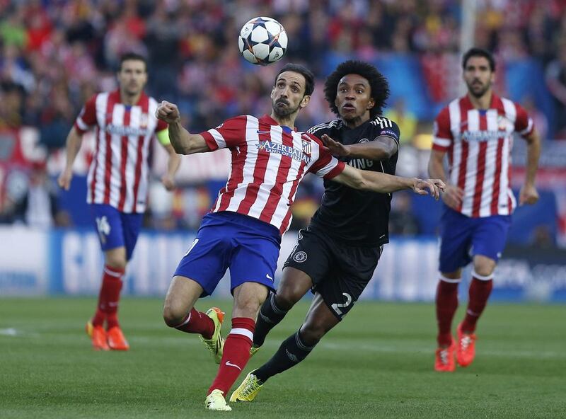 Atletico Madrid player Juanfran, left, clears the ball from Chelsea player Willian during their Champions League contest on Tuesday. Andres Kudacki / AP / April 22, 2014