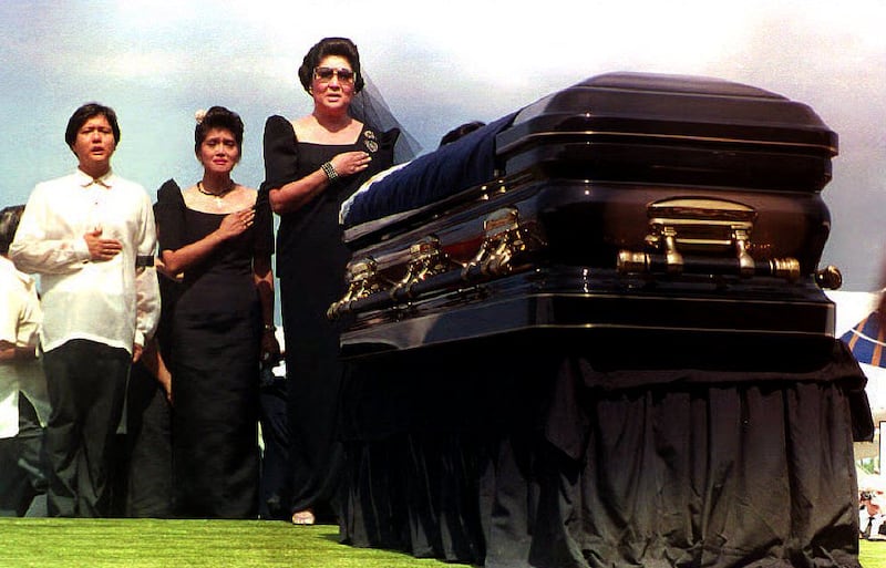 Imelda Marcos, right, and her children Ferdinand Marcos Jr and Imee Manotoc sing the Philippines national anthem as they stand by the coffin of Ferdinand Marcos Sr in 1993. AFP