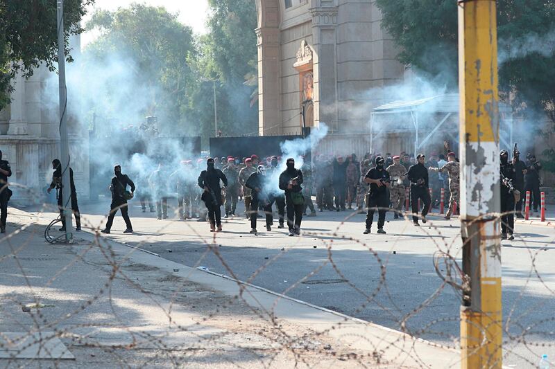Iraqi security forces fire tear gas to disperse anti-government protesters. AP Photo