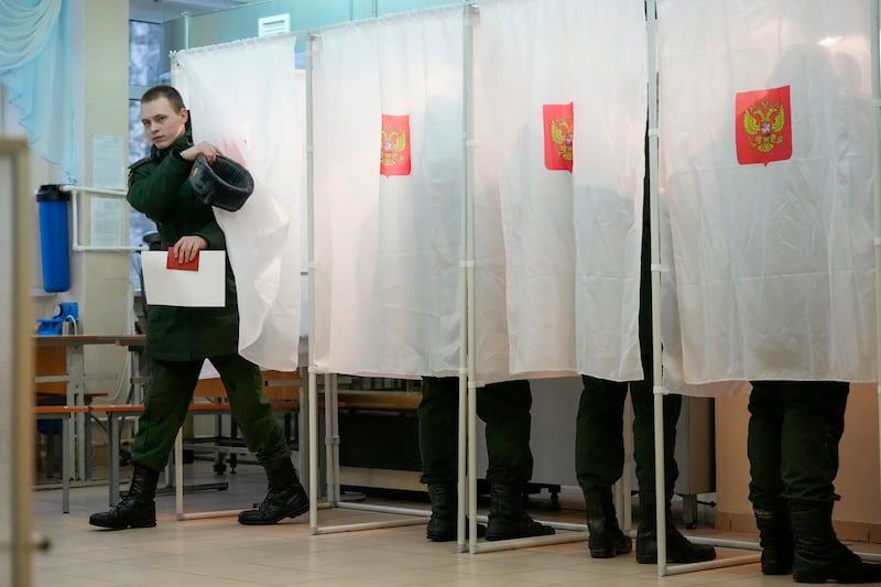 A Russian serviceman leaves a voting booth in St Petersburg. Mr Putin, 71, looks set for another six-year term that would enable him to overtake Joseph Stalin and become Russia's longest-serving leader for more than 200 years. AP