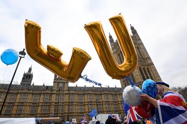 An anti-Brexit protester holds balloons opposite the Houses of Parliament in London. Reuters