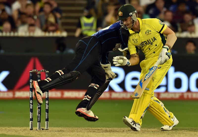 Australia's batsman Michael Clarke (R) gains his ground as New Zealand's wicketkeeper Luke Ronchi (L) dives in a run out attempt during the 2015 Cricket World Cup final between Australia and New Zealand in Melbourne on March 29, 2015. AFP PHOTO / Saeed KHAN
--IMAGE RESTRICTED TO EDITORIAL USE - STRICTLY NO COMMERCIAL USE-- (Photo by SAEED KHAN / AFP)