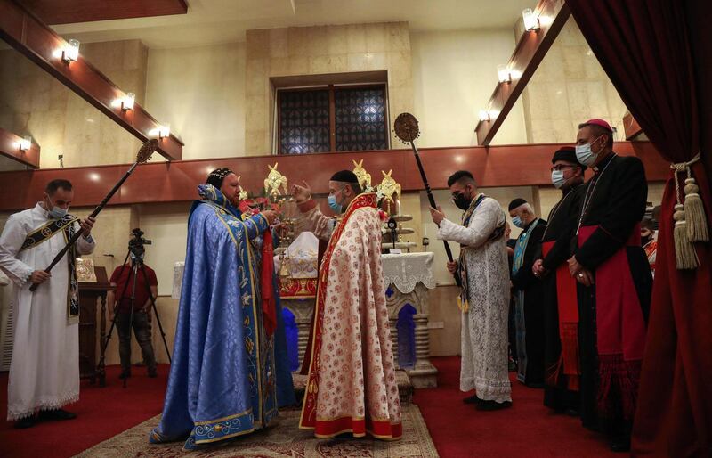 Syriac Orthodox Metropolitan Bishop of Mosul Mor Nicodemos Daoud Matti Sharaf (second left), leads an Easter service at the Syriac Orthodox Church of Um Al Noor in Erbil, the capital of the autonomous Kurdish region in northern Iraq. AFP