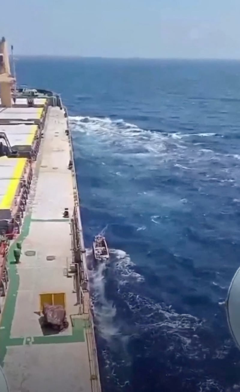 A small boat sails next to the MV Abdullah in a screengrab from a social media video released on March 12. Photo: Reuters