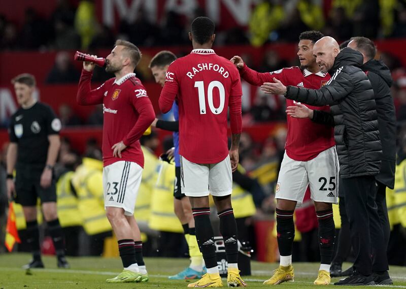 Manchester United manager Erik ten Hag talks to his players during a break in play. AFP