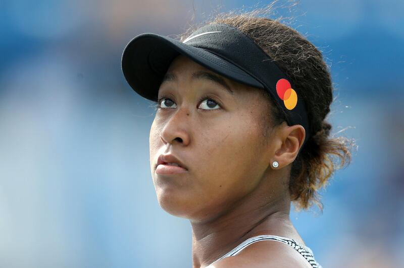 Naomi Osaka, of Japan, looks up a replay as she faces Sofia Kenin, of the United States, in the quarterfinals of the Western & Southern Open tennis tournament Friday, Aug. 16, 2019, in Mason, Ohio. Osaka withdrew from the match with an injury. (Kareem Elgazzar/The Cincinnati Enquirer via AP)