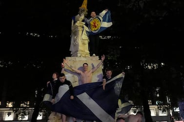 Scotland supporters stands on the statue of William Shakespeare in Leicester Square after the Euro 2020 draw with England. AP
