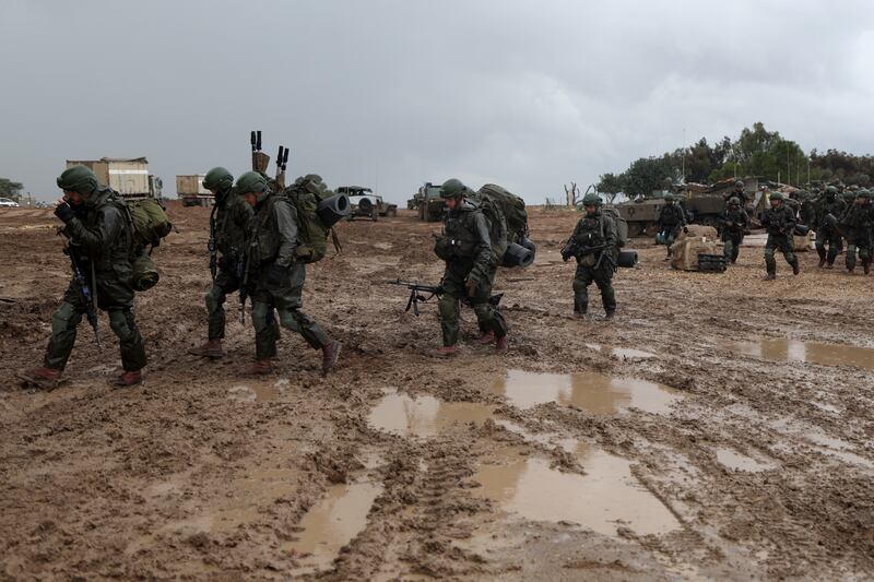 Israeli soldiers walk in the rain near the Gaza border. EPA