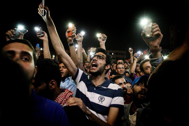 Protesters shout slogans and illuminate their mobile phones during a demonstration against a draft income tax law near the prime minister's office in Amman, Jordan, on Wednesday, June 6, 2018. The rise in global commodity prices and the ongoing expense of housing refugees from conflicts in neighboring Syria and Iraq has stretched the nation’s finances, while assistance from the Gulf this year has been limited to a grant from Kuwait. Photographer: Annie Sakkab/Bloomberg