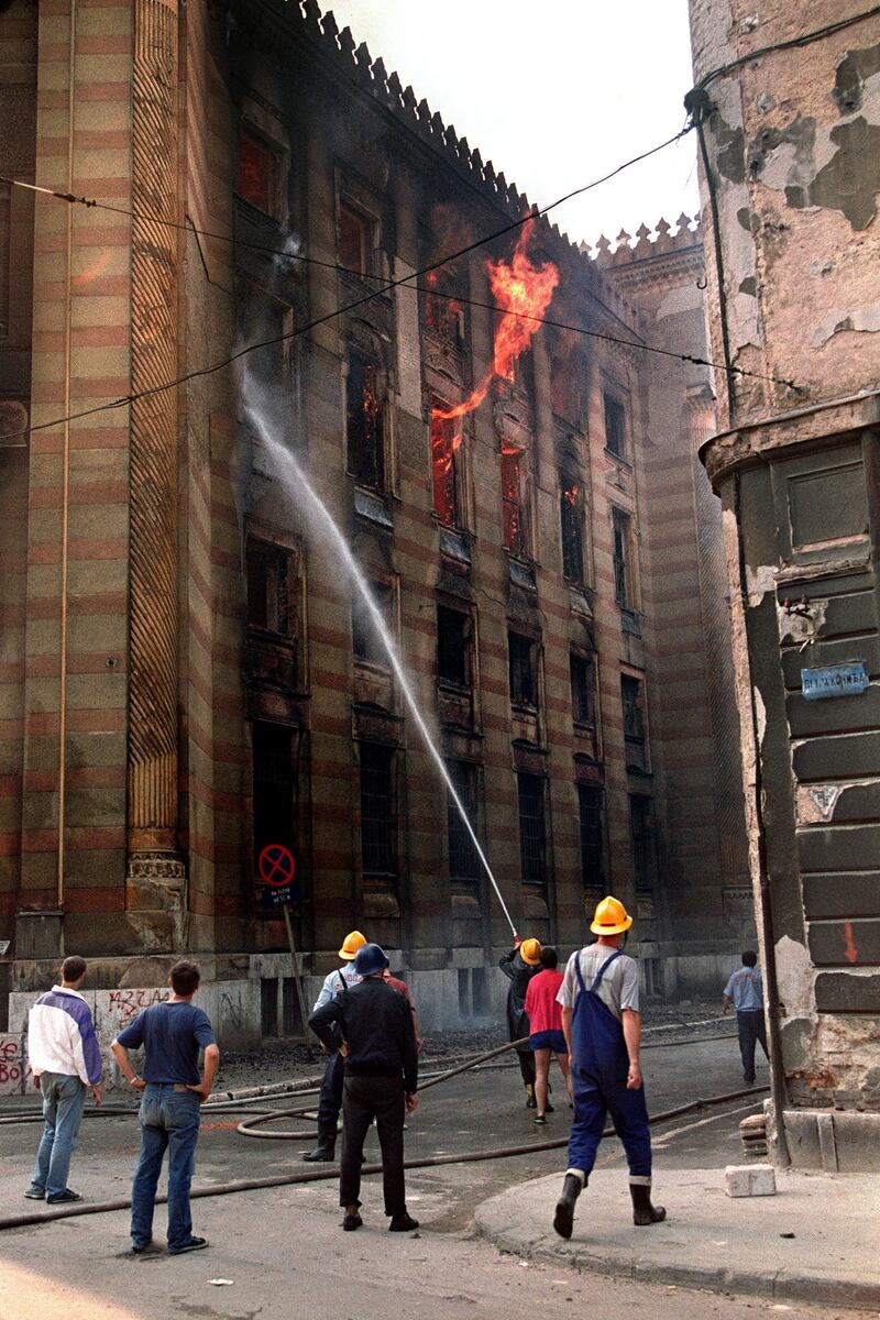 Firefighters douse flames inside the National Library in Sarajevo 26 August 1992. Thousands of books and historical documents are housed in the building which was hit by shells during artillery duels in the capital. An international conference in London met 26 August to resolve the conflict. (Photo by MANOOCHER DEGHATI / AFP)